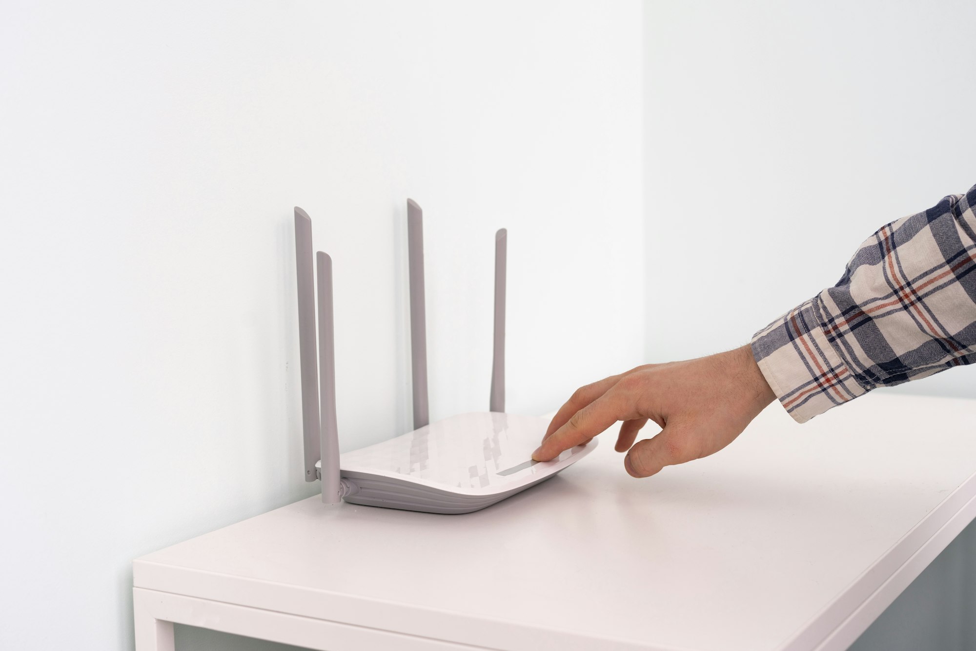 a hand push the power on button of the wifi router, internet connection equipment